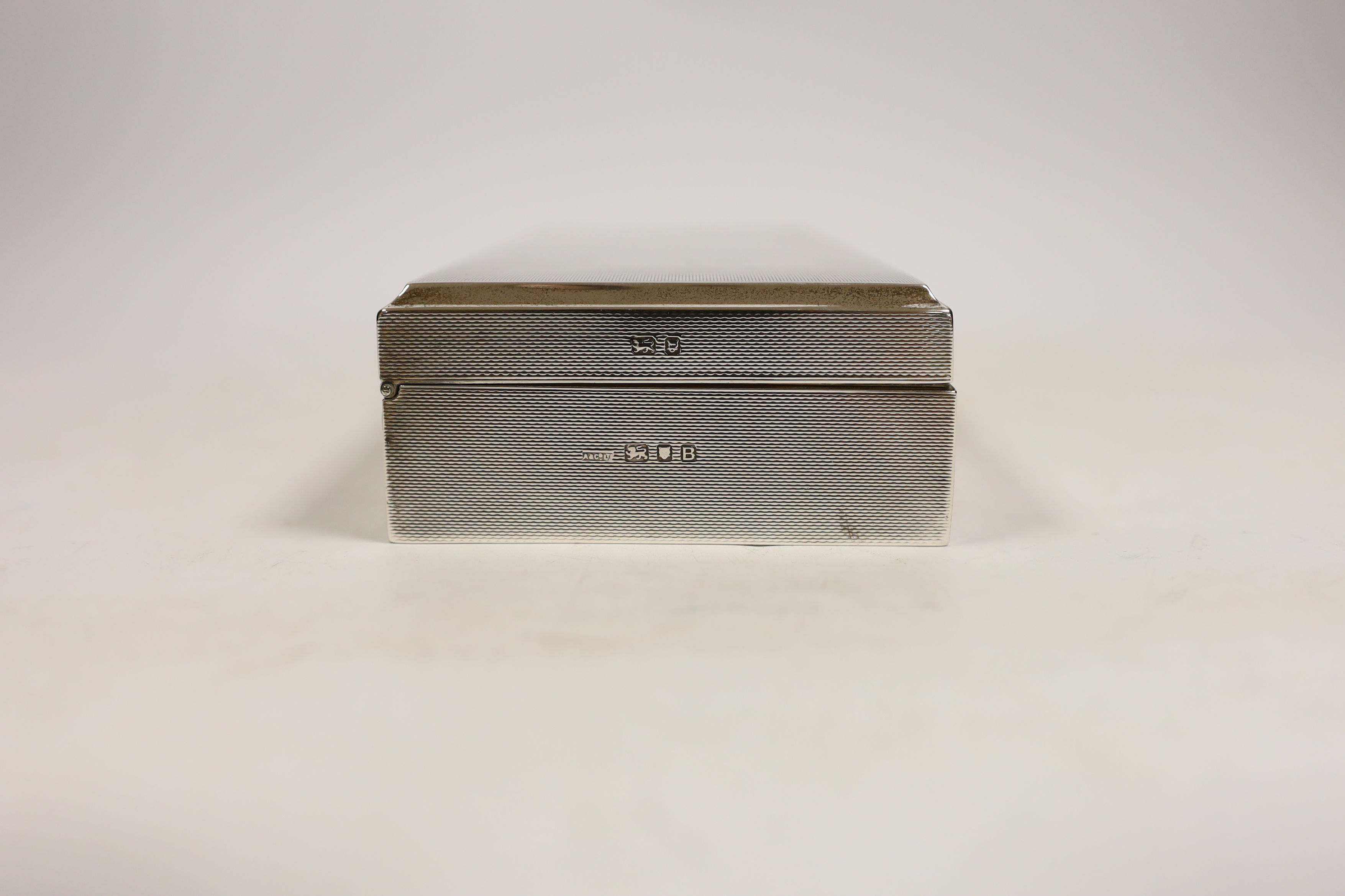 A George VI engine turned silver mounted rectangular cigarette box, Asprey & Co Ltd, London, 1937, 20.3cm.